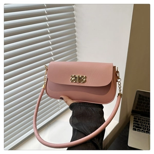 Détail d'un sac à main rose en cuir avec boucle métallique dorée à motif losanges
