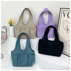 Detail of multi-pocket tote bags in khaki, purple, navy, and black nylon fabrics