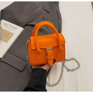 Détail du mini sac orange vif en similicuir avec bandoulière chaîne argentée