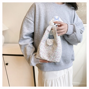 Détail du sac à main en toile à fleurs avec motif floral et accessoire peluche