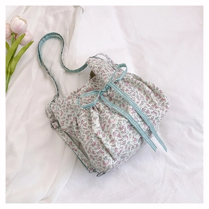 Detail of floral printed fabric shoulder bag with blue checkered drawstring and tulip background