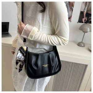 Détail du sac à bandoulière plissé noir avec foulard en soie et lettrage doré chic