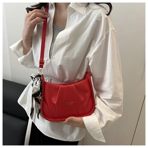Dettaglio della borsa hobo rossa a pieghe con foulard geometrico e tracolla regolabile