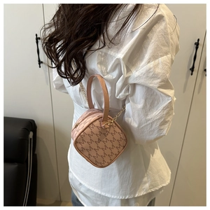 Détail du sac à main rose nude avec motif monogramme M et bandoulière dorée