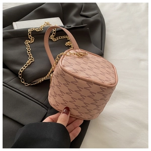 Détail d'un sac bandoulière rose-brun avec monogramme M et bandoulière chaîne dorée