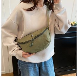 Detail of olive green crescent bag showing nylon texture and adjustable woven strap