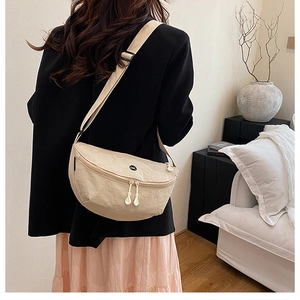 Chic beige crescent crossbody bag with OK logo shown from a stylish side perspective