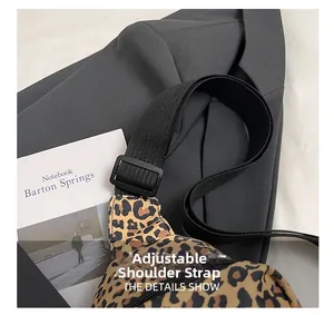 Detail showing the adjustable wide black nylon strap on the leopard print crossbody bag