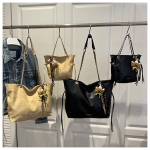 Detail of retro tote bags with chain straps, drawstring closure and bear charms