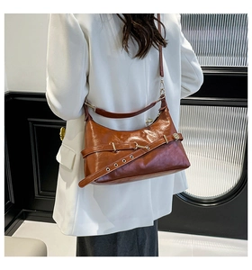 Gros plan du sac rétro en cuir marron caramel avec boucle métallique et œillets chic