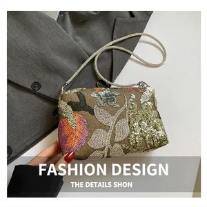 Detail of colorful leaf sequin embroidery and silver snake chain on the evening bag