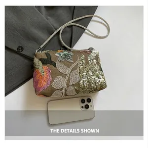 Detail shot of vintage sequins embroidery on crossbody bag with silver chain strap