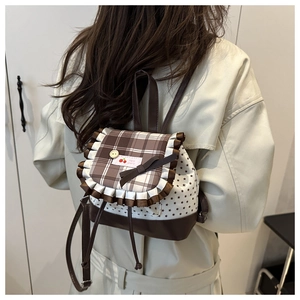 Detail of a mini backpack with brown plaid flap, star print and Hello Cherry embroidery