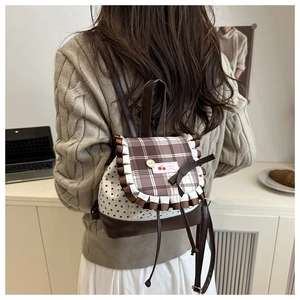 Detail of star pattern backpack with bow and cherry label on the checkered flap