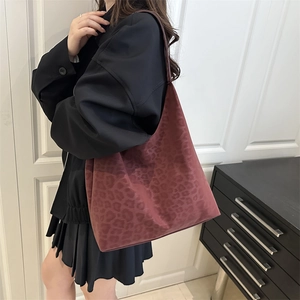 Vintage burgundy leopard print large tote bag for women shown on shoulder of a model