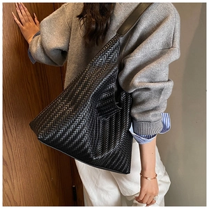 Detail of the black woven leather hobo shoulder bag featuring intricate craftsmanship