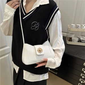 Sac à bandoulière blanc minimaliste avec boucle fleurie dorée porté par un mannequin