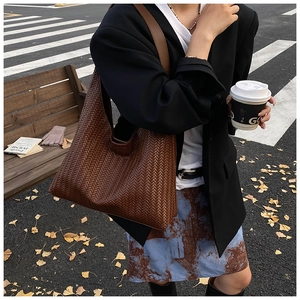 Close-up of the brown woven leather texture on a large shoulder tote bag for women