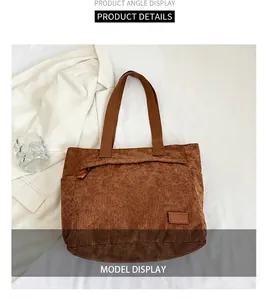 Detailed macro view of brown corduroy tote bag with zipper pocket and leather tag