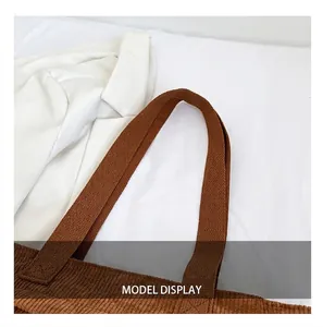 Detail of sturdy shoulder straps and corduroy texture on this dark brown tote bag