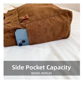 Detail of the side pocket capacity on a brown corduroy tote bag with a smartphone inside