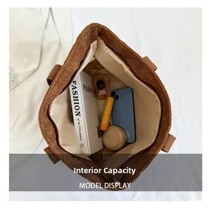Internal capacity of brown corduroy tote bag showing books and cosmetics storage
