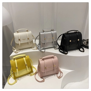 Mini textured leather backpacks in five colors displayed on white tiered steps