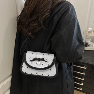 French style white textured shoulder bag with black bow and silver heart pendant detail