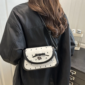 White pleated crossbody bag with black rabbit print and elegant bow pendant detail