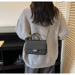 Details der schwarzen gesteppten Ledertasche mit Silberverschluss und Kettenriemen