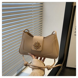 Détail du sac à main beige en similicuir doté d'un fermoir fleuri doré sophistiqué