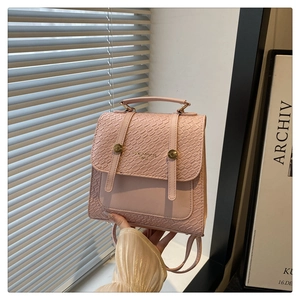 Close-up of pink faux leather backpack with crocodile texture and gold metal accents