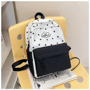 Détail d'un sac à dos à motif étoiles noir et blanc sur une chaise jaune