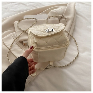 Détails du mini sac matelassé crème avec fermoir rotatif argenté et bandoulière chaîne