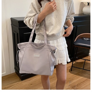 Detail of light purple canvas tote bag with drawstring design and fashion label