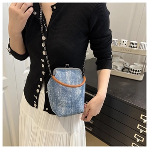 Gros plan du sac bandoulière rétro en denim avec fermoir métal et poignée en cuir