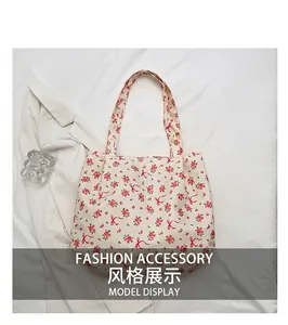 Detailed top view of floral canvas tote bag featuring pink roses and red ribbon prints