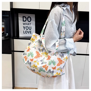 Détail de l'imprimé papillon coloré et de la large bandoulière du sac cabas en toile