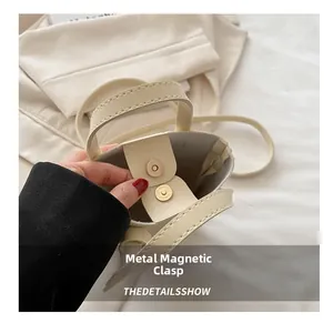 Dettaglio della chiusura magnetica in metallo e cuciture pulite sulla borsa color crema
