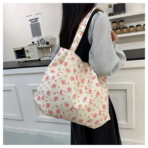 Vista dettagliata della borsa tote in tela con stampe floreali di rose e fiocchi