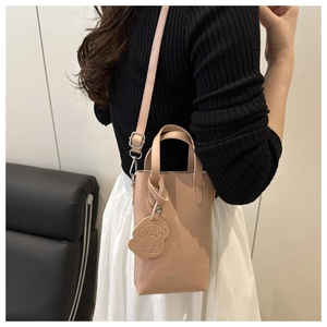 Mini lychee texture apricot tote bag shown as a crossbody on a female model