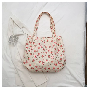 Close-up of lightweight tote bag featuring red floral print and bow tie patterns