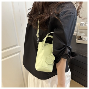 Detail of mint green mini tote bag with dog charm and white FASHION & BAGS lettering