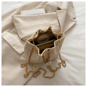 Vue de dessus du sac seau tissé beige montrant sa grande capacité pour portefeuille