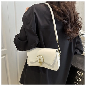 Detail of white faux leather shoulder bag with a gold metal lock and chain strap