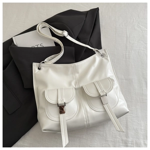 Detail of white PU leather tote with utility pockets and silver metal buckle accents