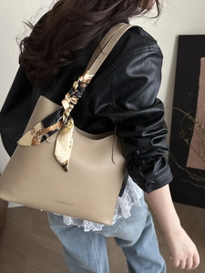 Minimalist beige tote bag with decorative silk scarf handle for 2025 fashion look