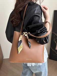 Brown faux leather tote bag with printed silk scarf and slim shoulder straps on a model