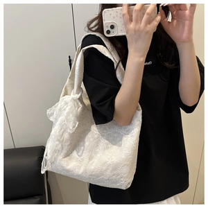 Detailed close-up of white floral lace tote bag with elegant embroidery and bow detail