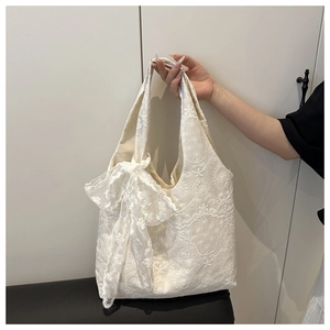 Détail du sac cabas en dentelle blanche brodée avec grand nœud et motifs floraux